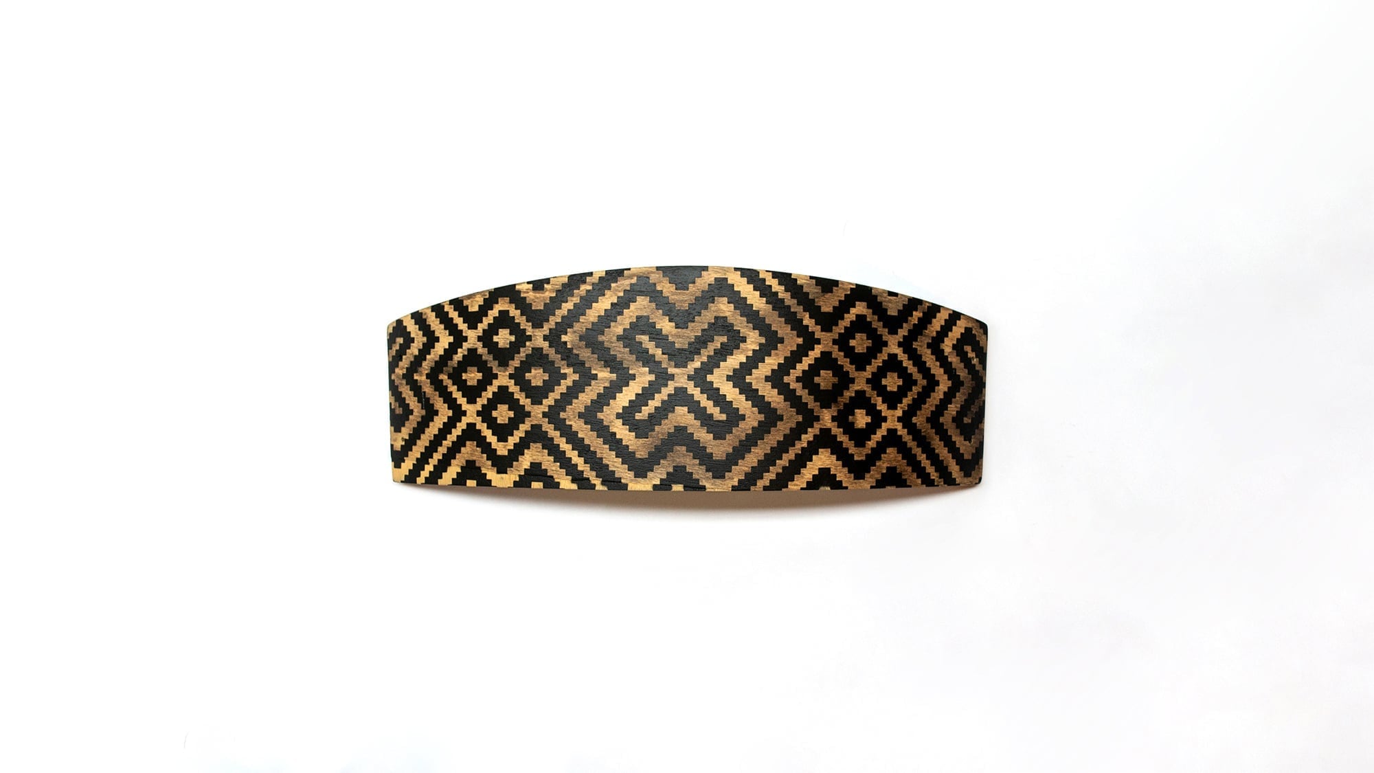 A curved wooden surface featuring a high-contrast black and gold geometric weave pattern.
